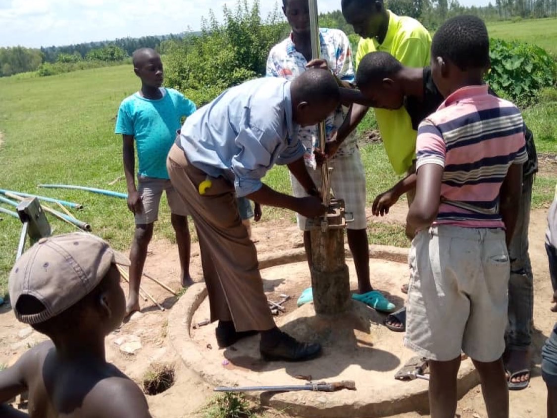 Het lokale team herstelt een waterpomp, waterproject 2023.